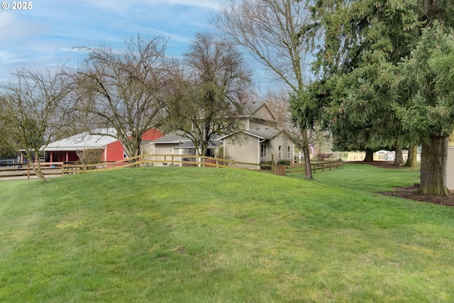 view of yard featuring an outdoor structure and fence