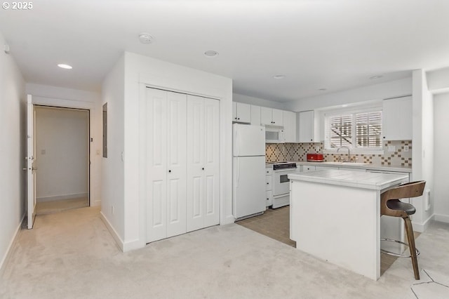 10272 NW Edgewood Dr, Portland, OR 97229 - kitchen with white appliances, tile counters, a sink, white cabinets, and recessed lighting