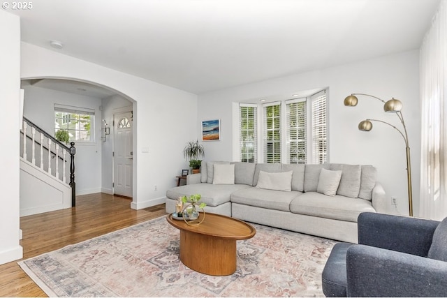 10272 NW Edgewood Dr, Portland, OR 97229 - living room featuring wood finished floors, arched walkways, stairs, and baseboards