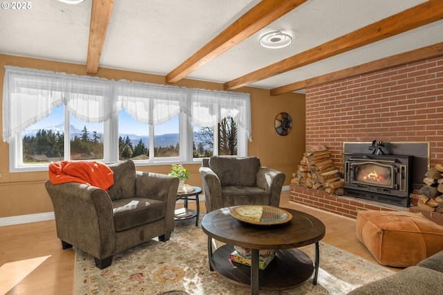 living area with beam ceiling, baseboards, and wood finished floors