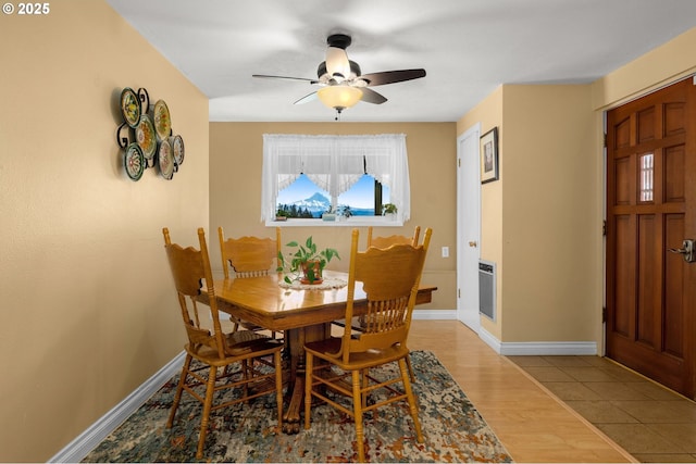 dining space featuring a ceiling fan, baseboards, and wood finished floors