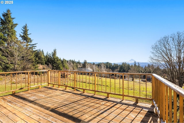 wooden deck featuring a lawn and a mountain view