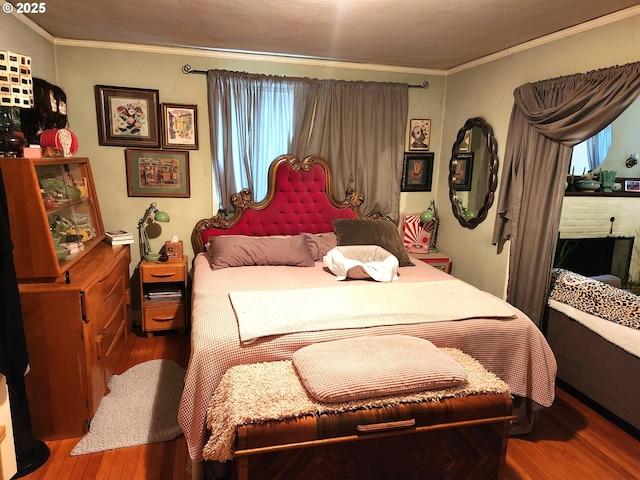 bedroom featuring multiple windows, crown molding, and wood-type flooring