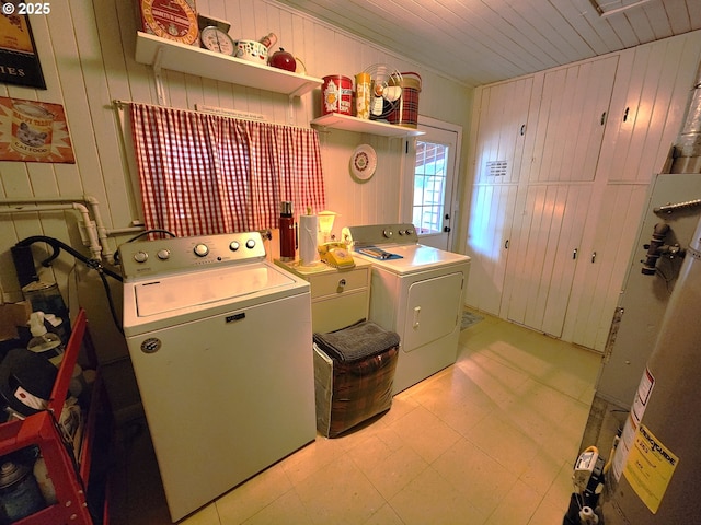 washroom with washing machine and dryer, water heater, wooden ceiling, and wood walls