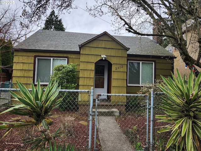 bungalow featuring a shingled roof, a gate, and a fenced front yard