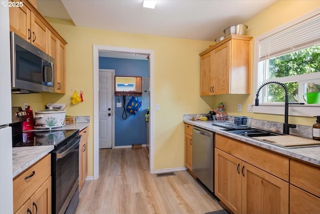 996 14th St, Salem, OR 97302 - kitchen featuring stainless steel appliances, a sink, light wood finished floors, light countertops, and baseboards