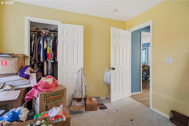 carpeted bedroom featuring baseboards and a closet
