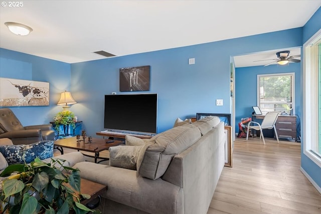 living room with light wood-style floors and a ceiling fan