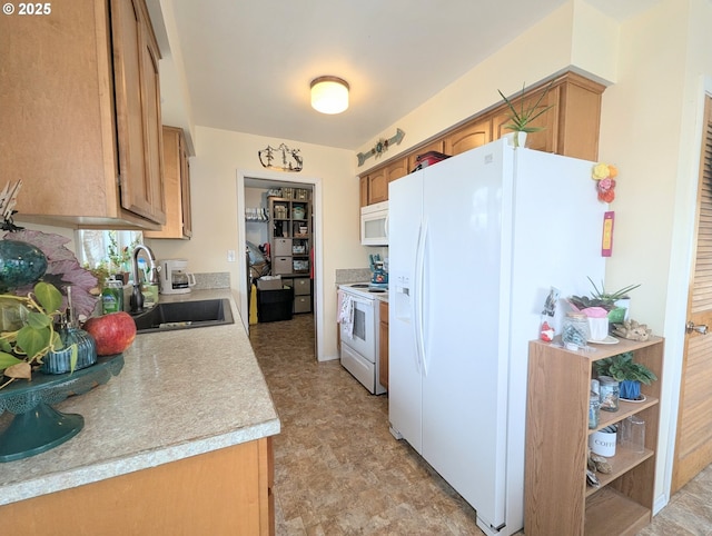 kitchen with brown cabinets, white appliances, light countertops, and a sink