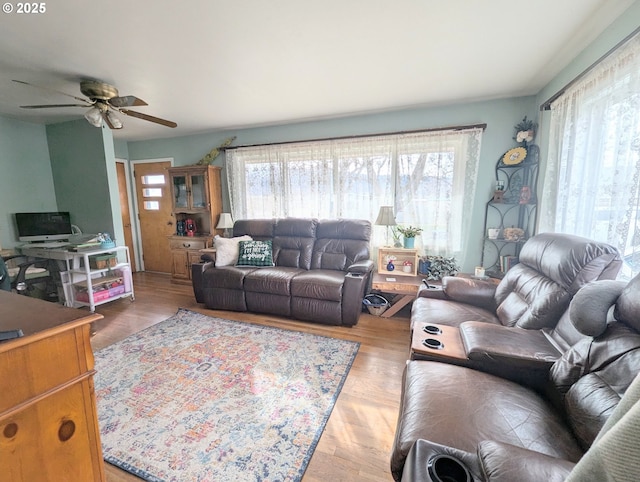 living area with wood finished floors and a ceiling fan