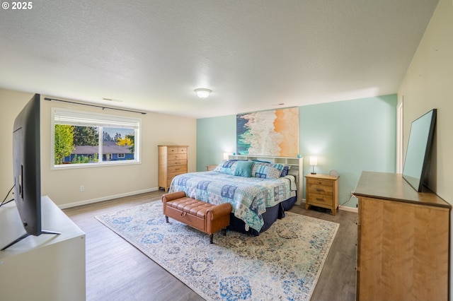 bedroom with baseboards and wood finished floors