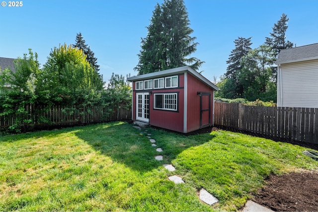 view of outdoor structure with an outdoor structure, french doors, and a fenced backyard