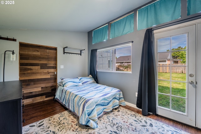 bedroom with baseboards, multiple windows, and wood finished floors