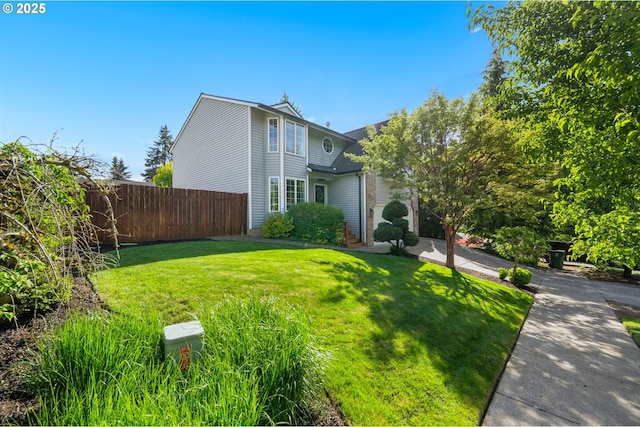 exterior space with a lawn and fence