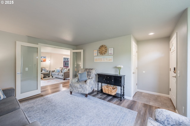 living room featuring recessed lighting, baseboards, wood finished floors, and french doors