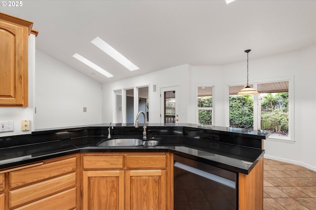 kitchen with light tile patterned flooring, vaulted ceiling with skylight, dishwashing machine, and sink