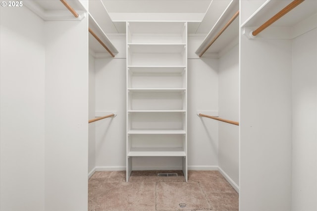 walk in closet featuring light colored carpet