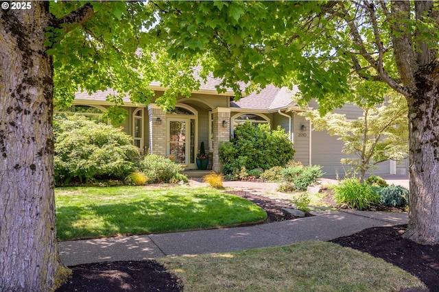 view of front of property featuring a garage and a front lawn