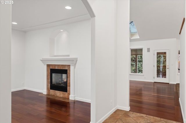 unfurnished living room featuring dark hardwood / wood-style floors and a tiled fireplace