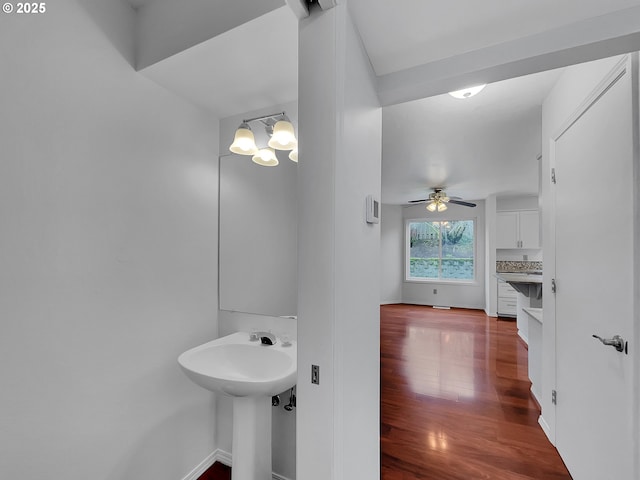 bathroom featuring ceiling fan with notable chandelier, wood finished floors, and baseboards