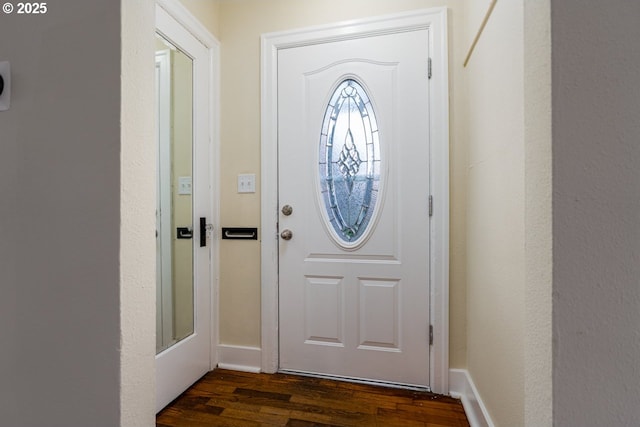 entryway with dark wood finished floors and baseboards