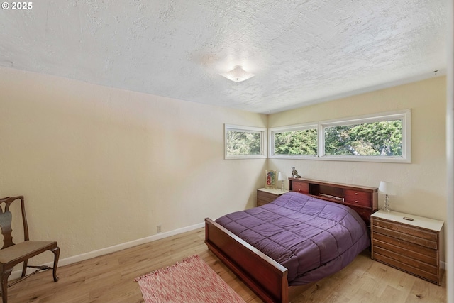 255 Coast Guard Hill Rd, Port Orford, OR 97465 - bedroom with light wood-style flooring, baseboards, and a textured ceiling