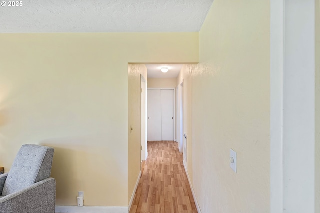 255 Coast Guard Hill Rd, Port Orford, OR 97465 - hall featuring baseboards, a textured ceiling, and light wood-type flooring