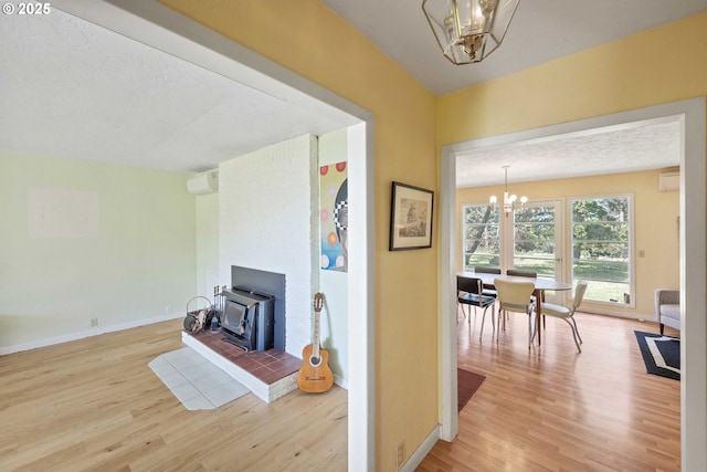 255 Coast Guard Hill Rd, Port Orford, OR 97465 - living area featuring baseboards, wood finished floors, a wood stove, and a chandelier