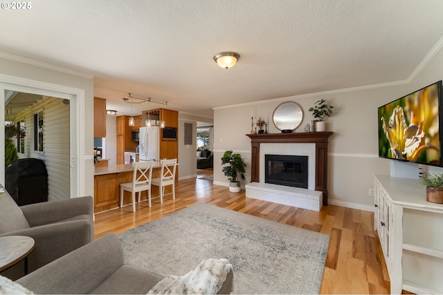 1025 S Grant St, Canby, OR 97013 - living area featuring light wood finished floors, a brick fireplace, crown molding, and a textured ceiling