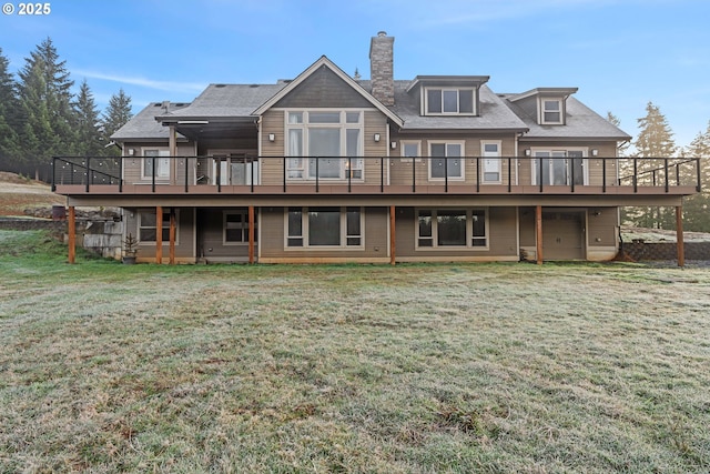 rear view of property featuring a deck, a yard, and a chimney