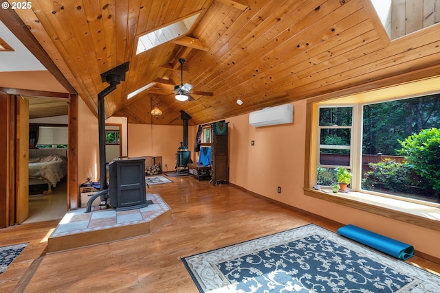 91625 W Fork Rd, Deadwood, OR 97430 - living area with a wood stove, a wall unit AC, a skylight, a ceiling fan, and wood finished floors