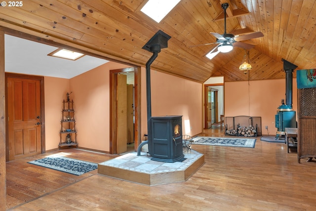 91625 W Fork Rd, Deadwood, OR 97430 - living area with a wood stove, lofted ceiling, wood finished floors, ceiling fan, and a skylight
