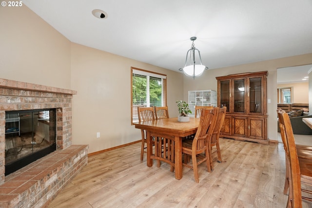 12705 NE 101st St, Vancouver, WA 98682 - dining room featuring light wood-style floors, a brick fireplace, and baseboards