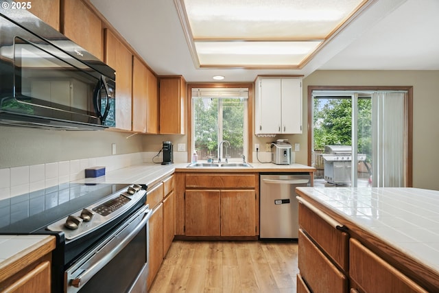 12705 NE 101st St, Vancouver, WA 98682 - kitchen with stainless steel appliances, a sink, tile counters, light wood finished floors, and plenty of natural light