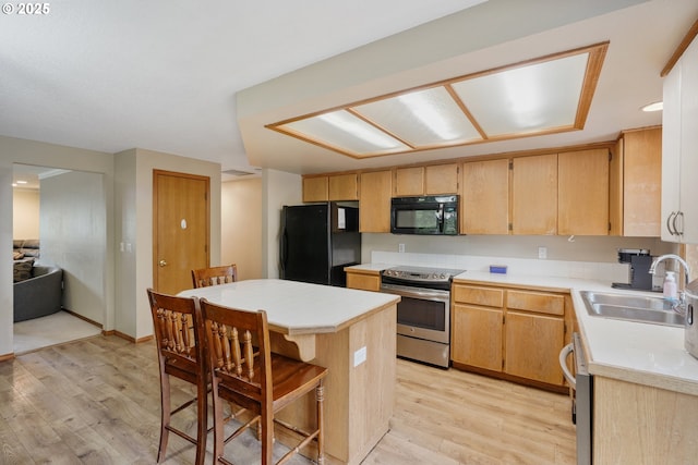 12705 NE 101st St, Vancouver, WA 98682 - kitchen featuring black appliances, a sink, light wood-style floors, and light countertops