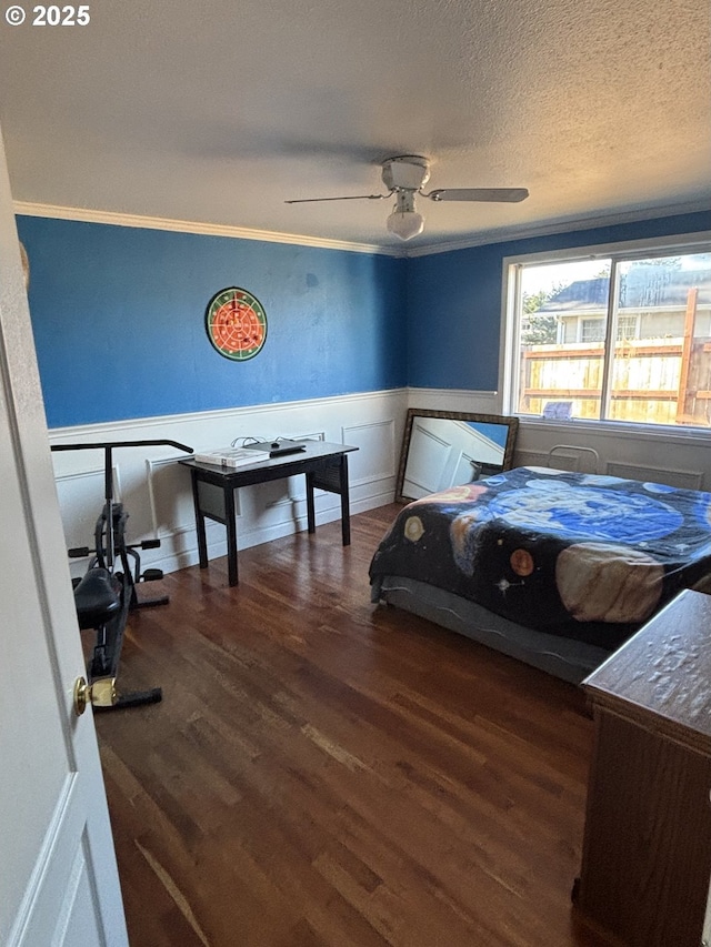 bedroom with ceiling fan, ornamental molding, dark hardwood / wood-style flooring, and a textured ceiling