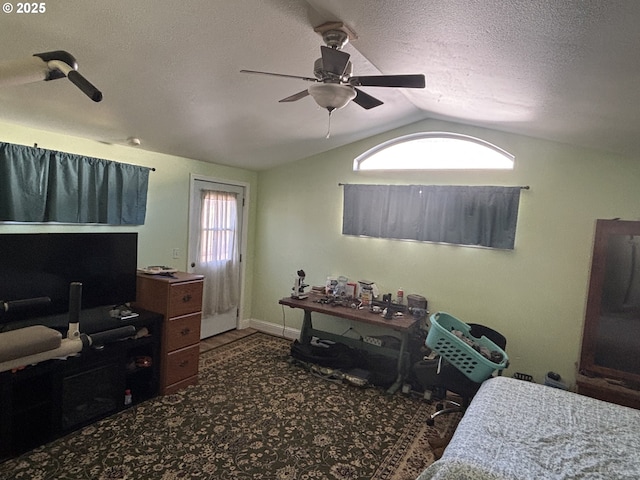 bedroom featuring ceiling fan, vaulted ceiling, and a textured ceiling