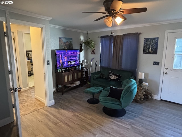 living room featuring hardwood / wood-style flooring, crown molding, and ceiling fan