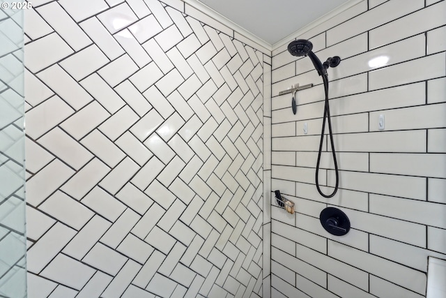 bathroom featuring crown molding and tiled shower