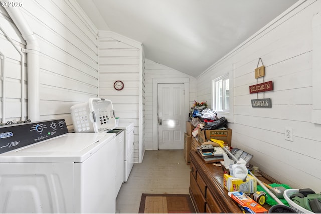 laundry area featuring laundry area, wood walls, light wood-style flooring, and washing machine and clothes dryer