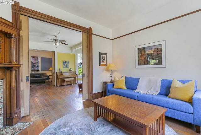 living area with wood-type flooring and a ceiling fan