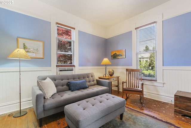 sitting room with wainscoting, hardwood / wood-style flooring, plenty of natural light, and cooling unit