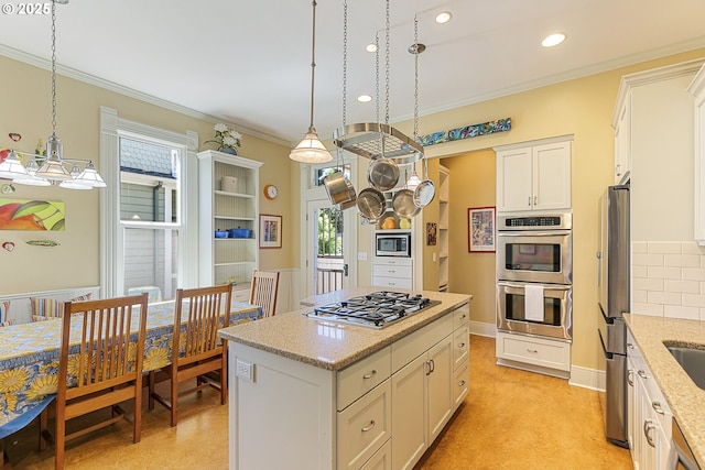 kitchen featuring appliances with stainless steel finishes, ornamental molding, white cabinetry, decorative light fixtures, and a kitchen island