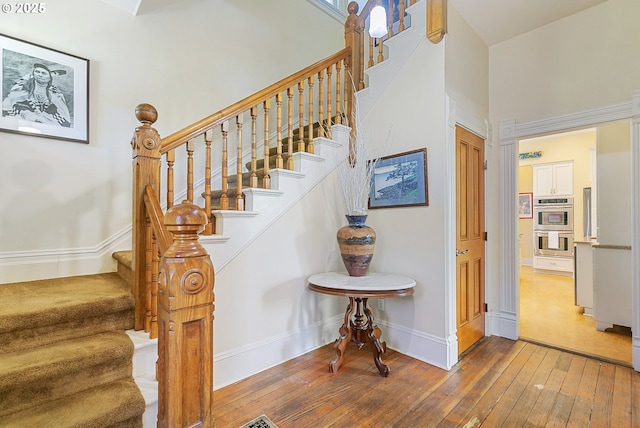 stairs with hardwood / wood-style flooring and baseboards