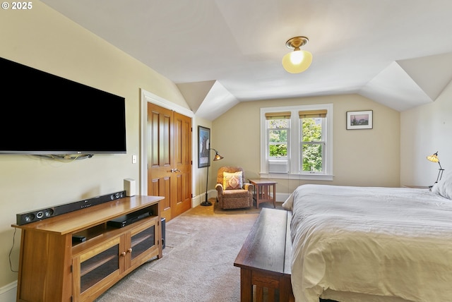 bedroom featuring lofted ceiling and light carpet