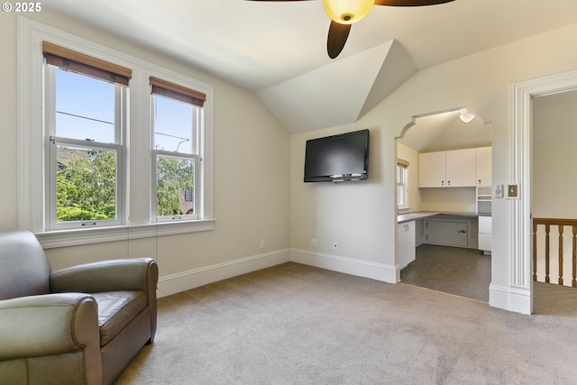 sitting room with vaulted ceiling, carpet, a ceiling fan, and baseboards