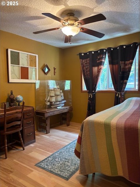 610 SE Maple St, Oakland, OR 97462 - bedroom featuring a textured ceiling, light wood-style floors, and ceiling fan