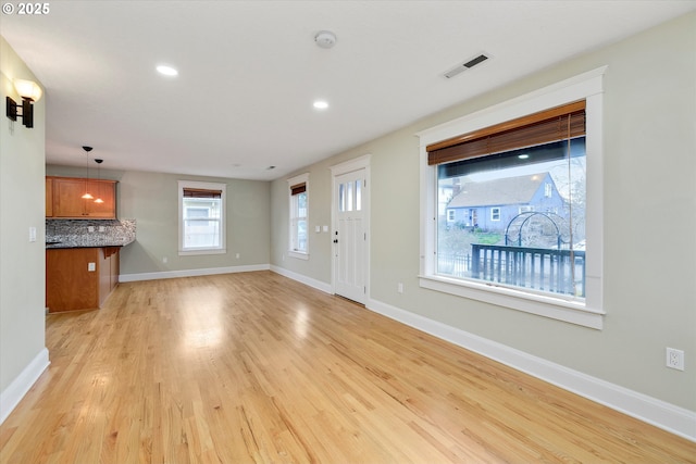 unfurnished living room with recessed lighting, baseboards, visible vents, and light wood finished floors