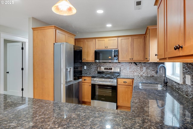 kitchen with visible vents, dark stone counters, a sink, appliances with stainless steel finishes, and tasteful backsplash