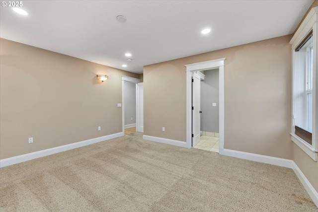 unfurnished room with recessed lighting, baseboards, and light colored carpet